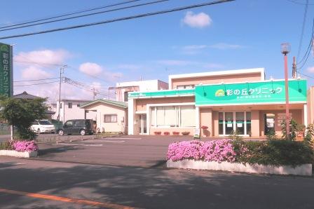 ツツジのピンクと、クリニック看板の色がマッチして、青空で映えて.. 彩の丘クリニック 上里町 内科